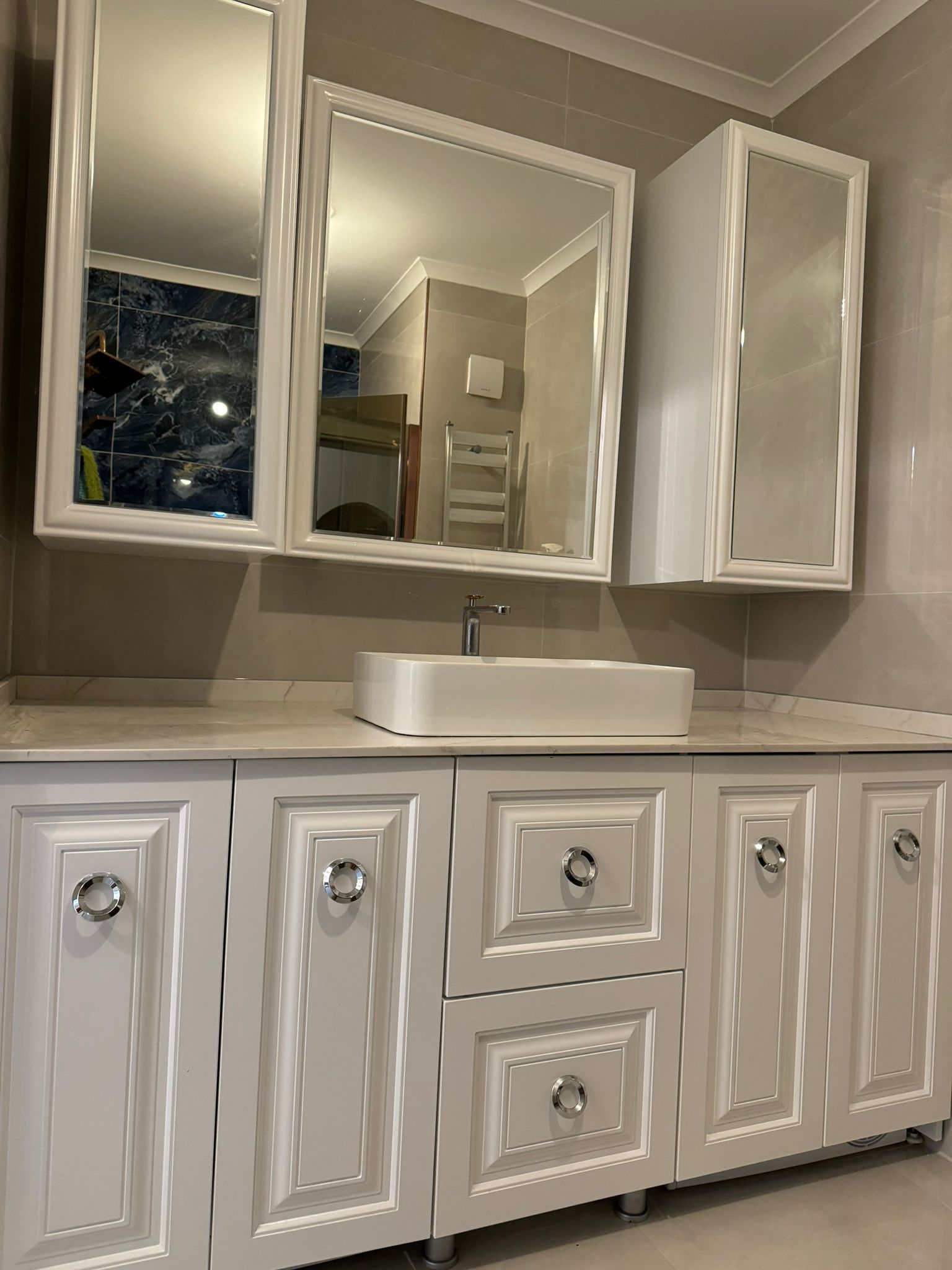 Derin lacivert duvarlar, sıcak ahşap öğeler ve zarif fildişi aksanlarla lüks mobilya showroomu iç mekanı