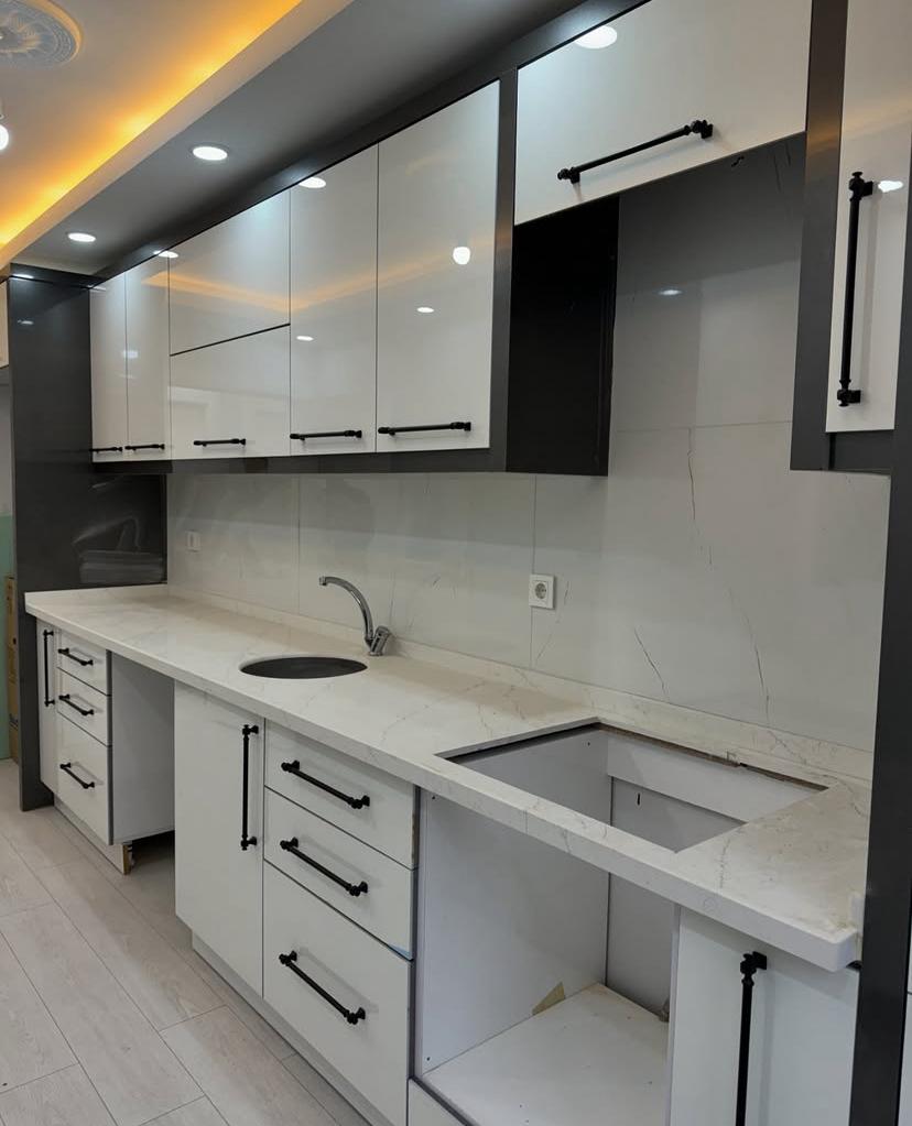 Modern oturma odasında yumuşak ışık yayan fildişi şapkalı mat siyah ayaklı lambader